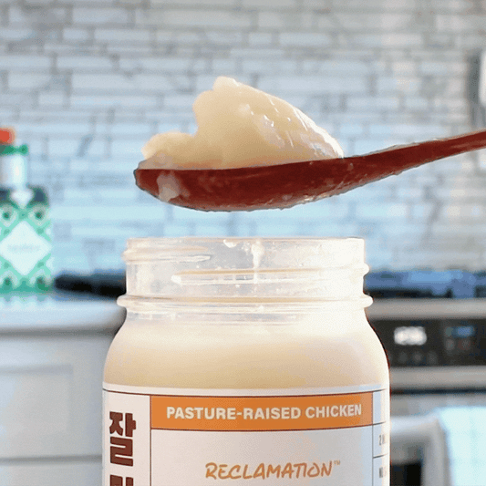 Spoonful of Reclamation Korean-Style Chicken Bone Broth jiggling on spoon in front of kitchen counter
